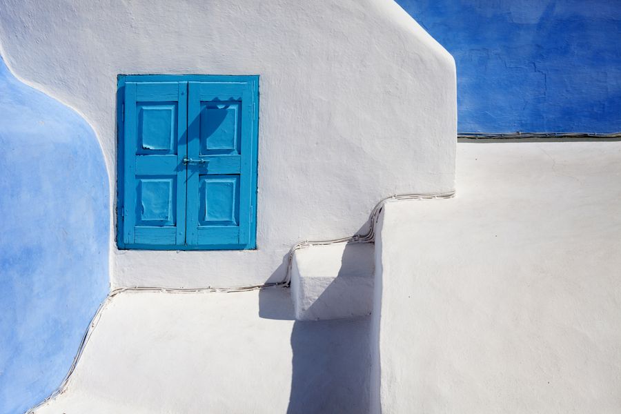 a blue wooden door on a white concrete wall — The window seat office: emails sent somewhere over the ocean.