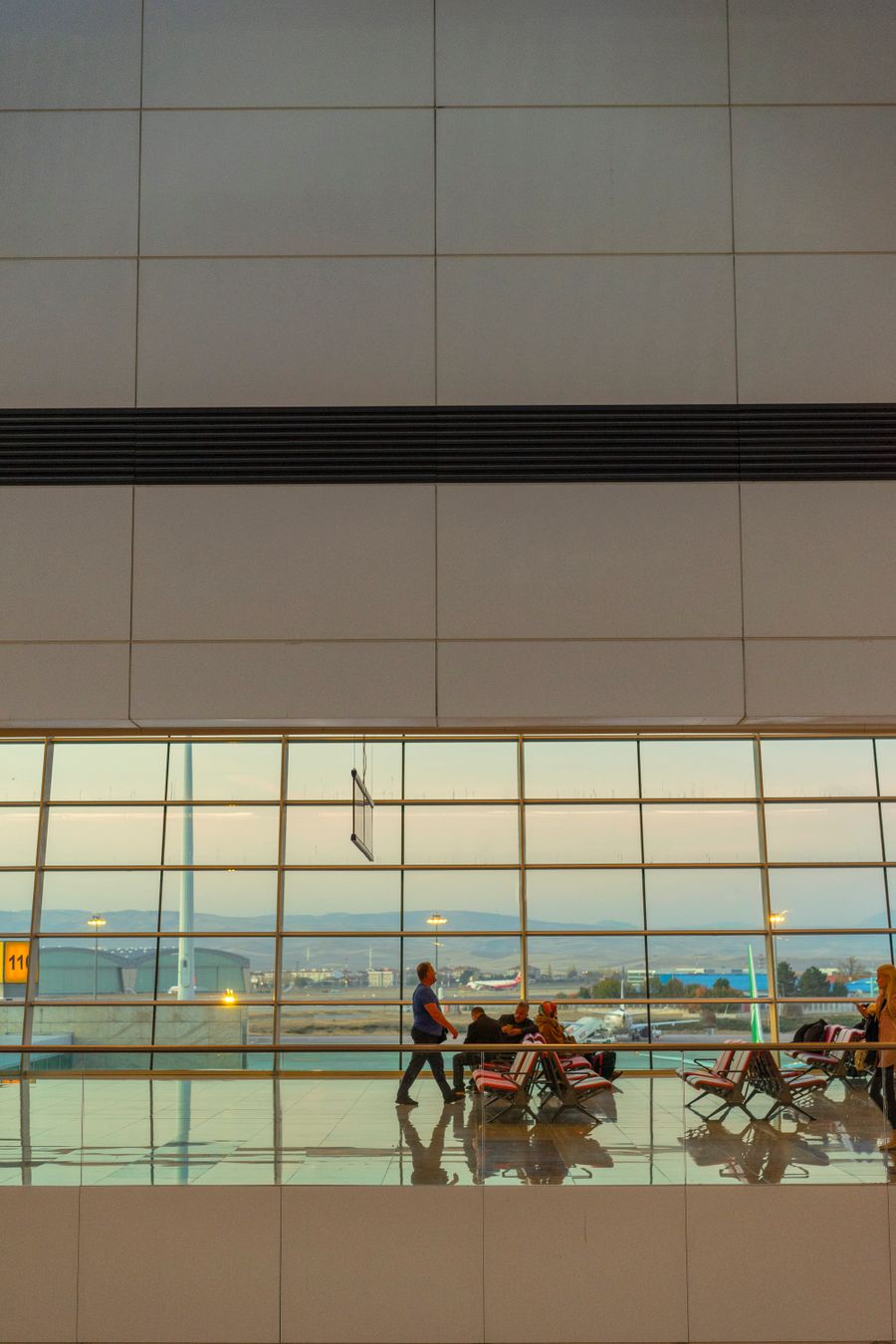 people at an airport — Rainy-day backup plan: indoor attractions researched from the hostel bunk.
