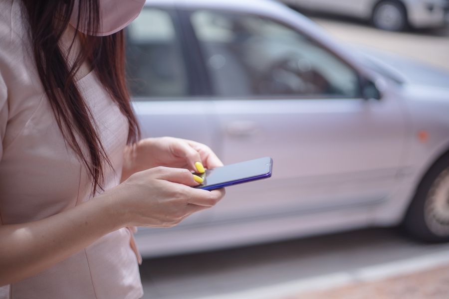 woman in pink blouse texting on a smartphone