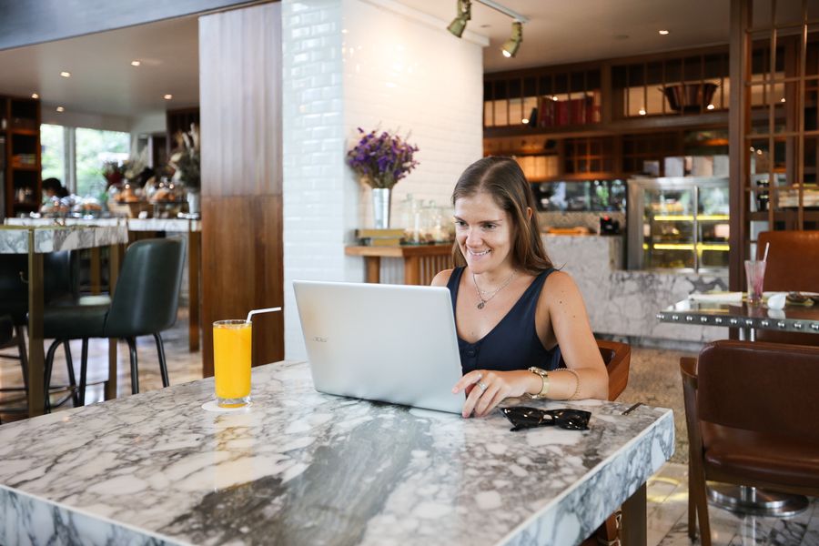 a woman inside a restaurant using a laptop — Changelog: Sem “correções de bugs e melhorias” — cada entrada diz o que realmente mudou.