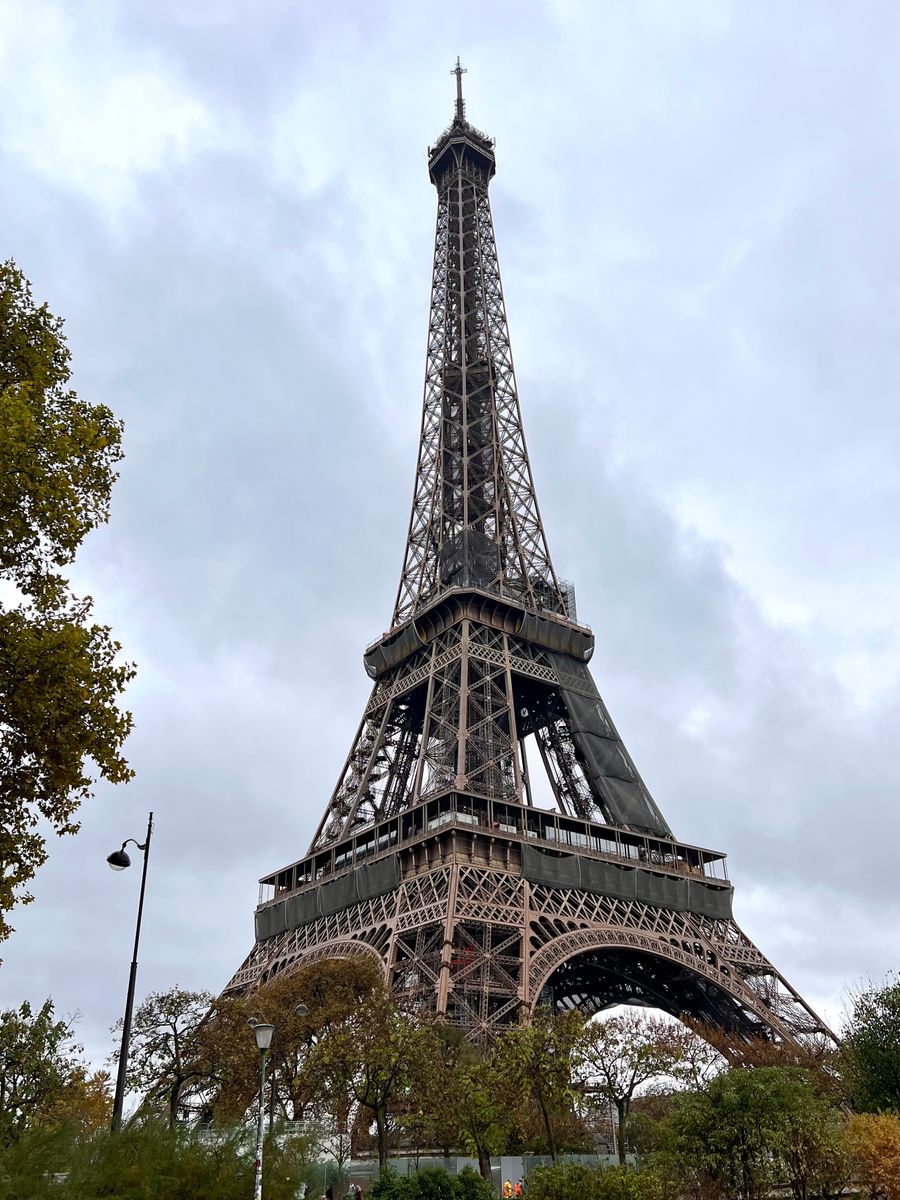 low angle photo of eiffel tower under cloudy sky — A feira noturna de Timor-Leste: barracas mapeadas, pratos imperdíveis traduzidos.