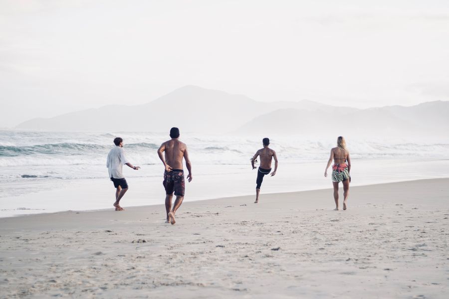 a group of men on the beach playing soccer — Check-in lines move faster when your documents are on your phone.