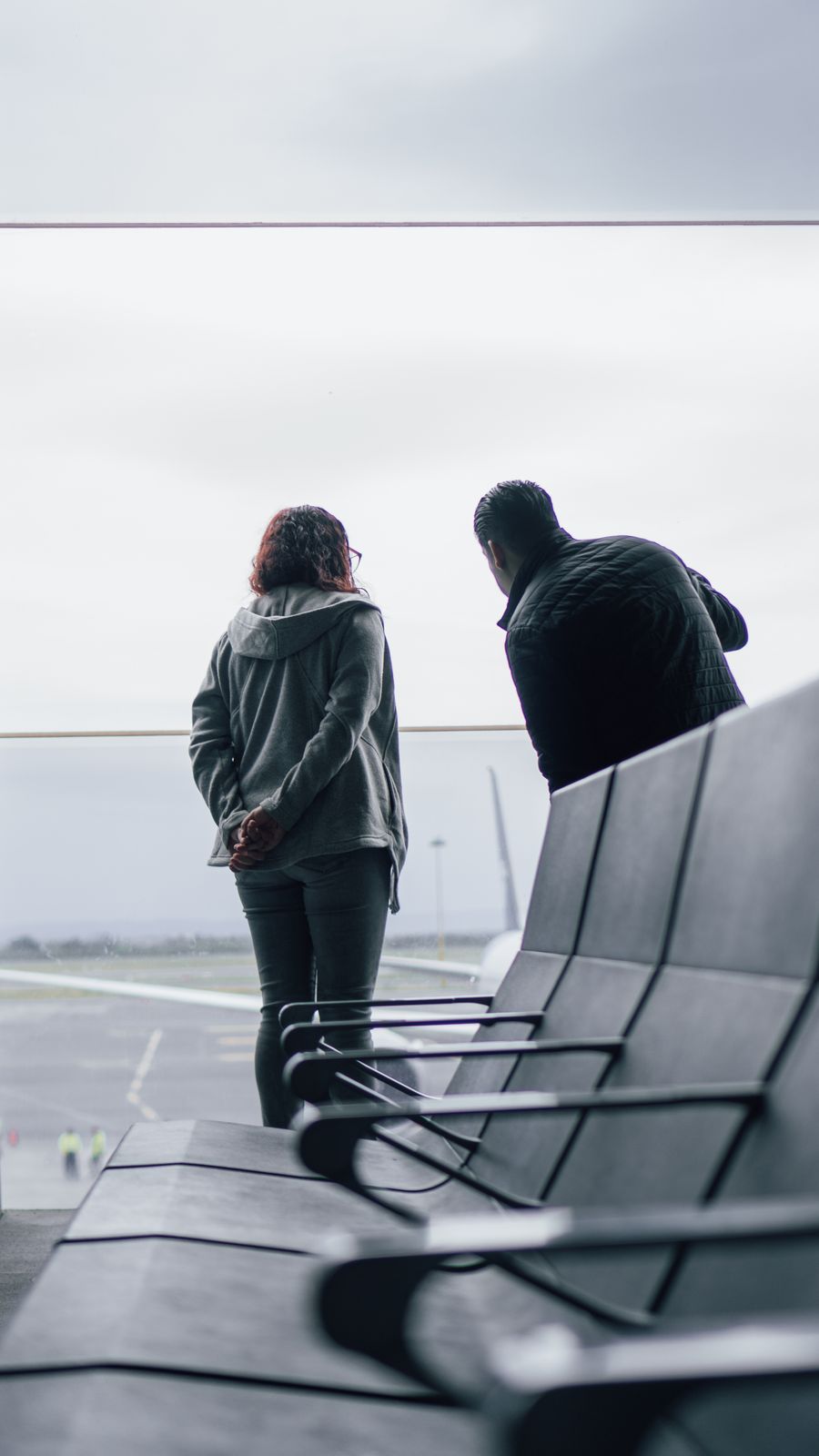 woman and man standing near windows on airport — Docs: Check-in no terraço: cartões de embarque e chaves do hotel, tudo no celular.