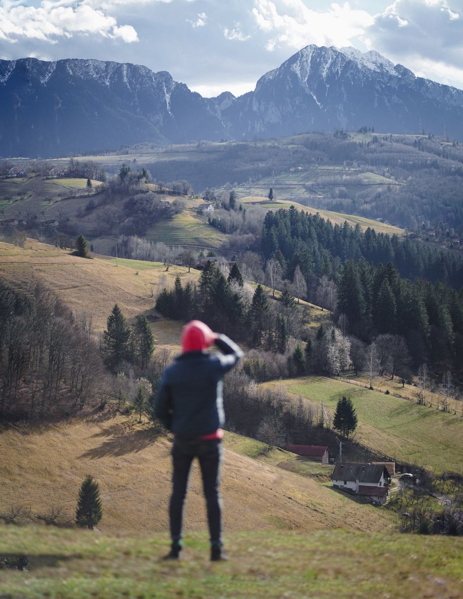 man standing with mountains behind — Duty-free browsing: price-checked against home before buying.