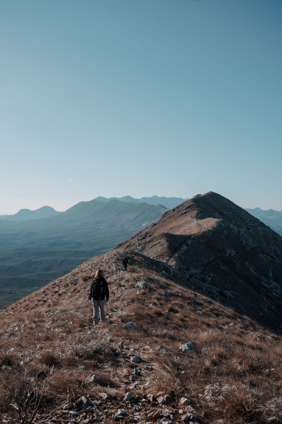 woman hiking on hill — The FAQ below Multi-Country eSIM Guide answers the six questions everyone asks first.