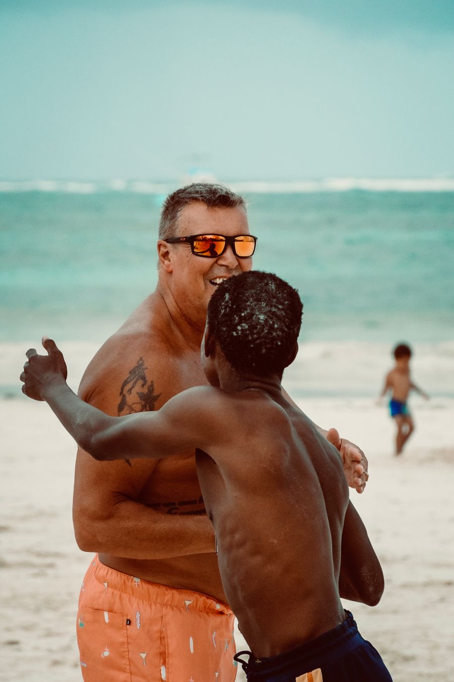 a man in sunglasses and a shirt is standing on the beach with another man — One tool, zero cost, instant answers — that's the whole deal.