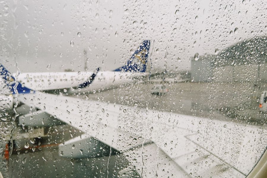rainy airport view from airplane window — Caça a souvenirs em Timor-Leste com conversão de moeda ao vivo no bolso.
