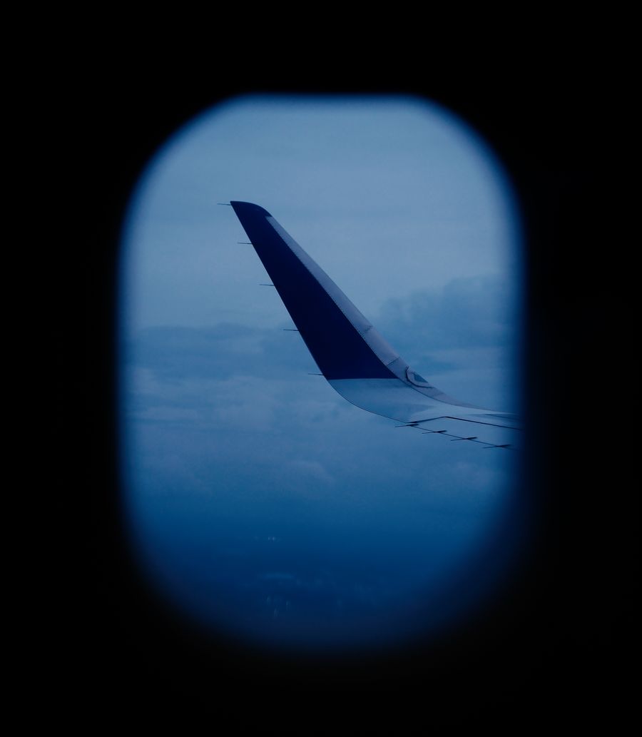 aerial view of airplane wing through window — Casa de câmbio, pulada: o celular paga na taxa real.