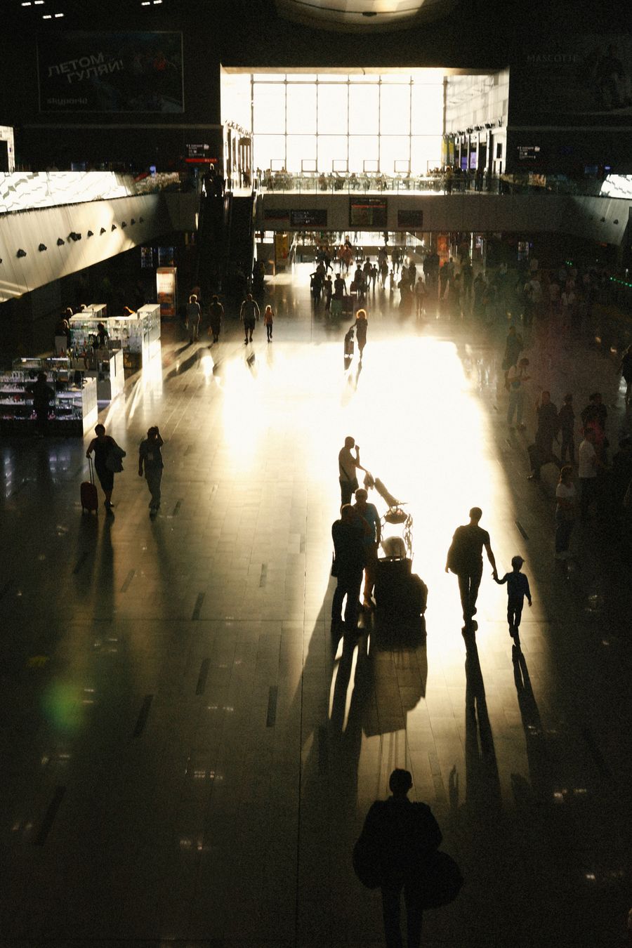 busy airport terminal with silhouetted travelers — Developers: As chaves de API giram com um clique — o painel torna isso entediante.