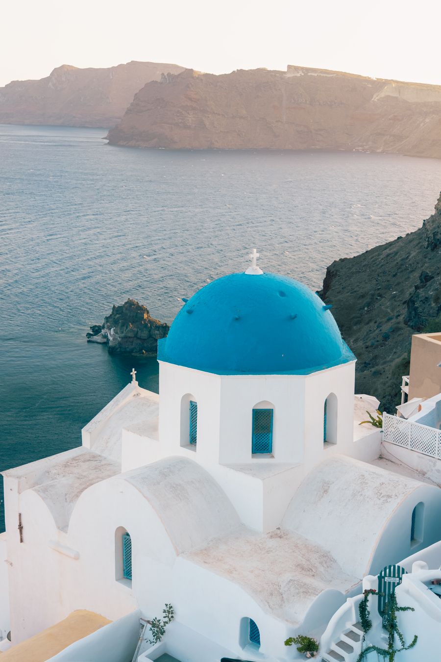 iconic blue dome church overlooking santorini coastline