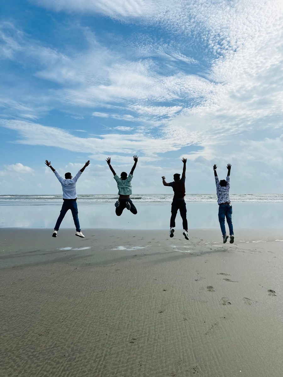 friends jumping together on a beach