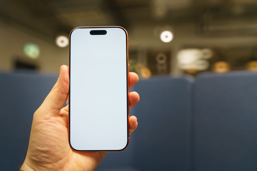 blank smartphone screen held in hand indoors