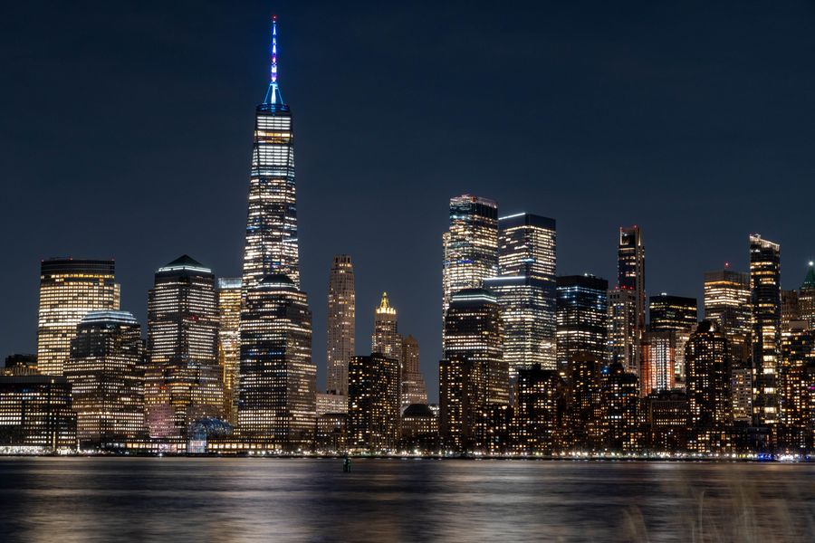 stunning nighttime view of new york city skyline — The conference badge: QR ticket scanned, session schedule synced.