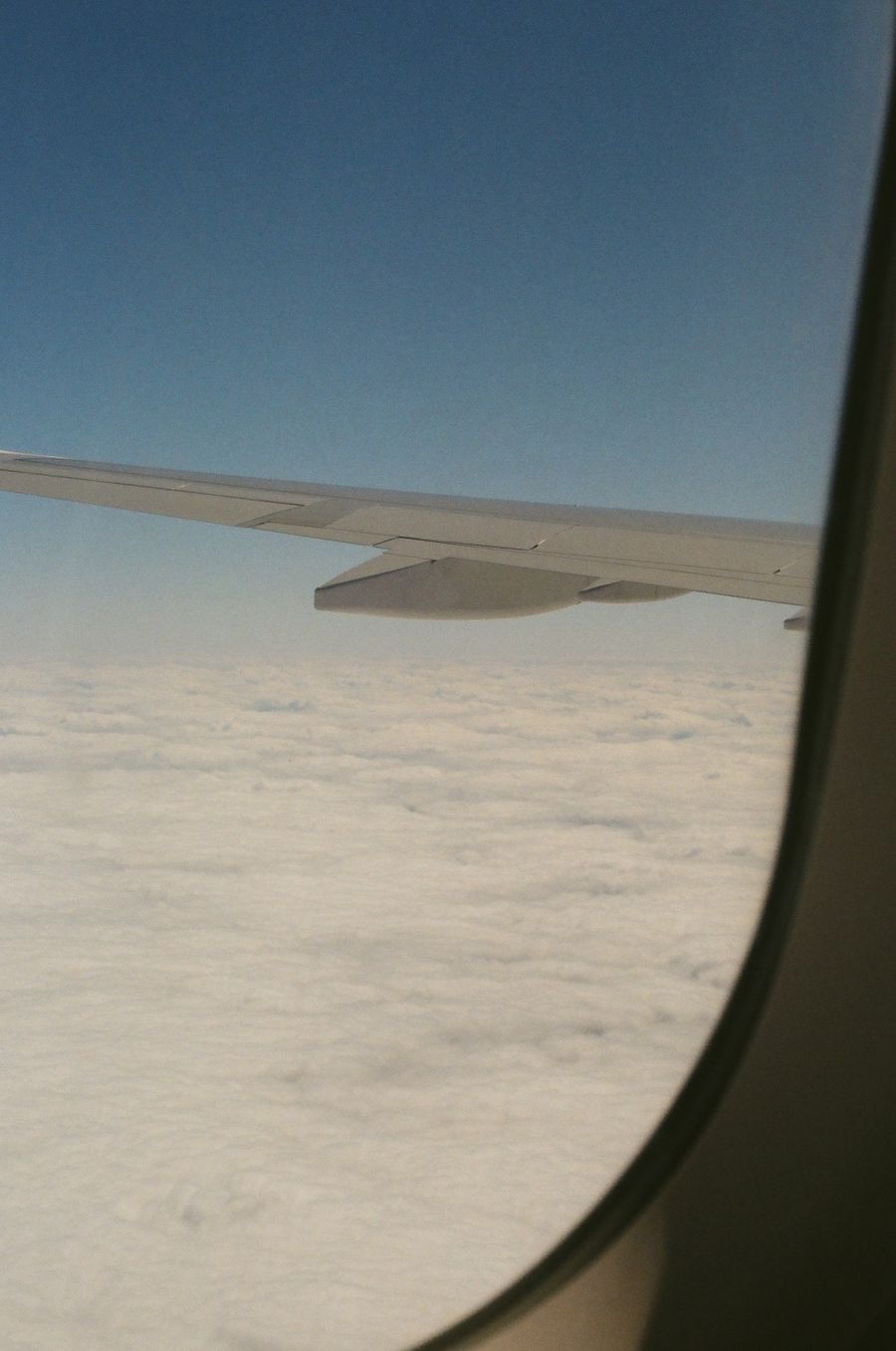 aerial view from plane window showing clouds — A road trip por São Tomé and Príncipe: paradas de combustível planejadas, playlist baixada, mapa offline.
