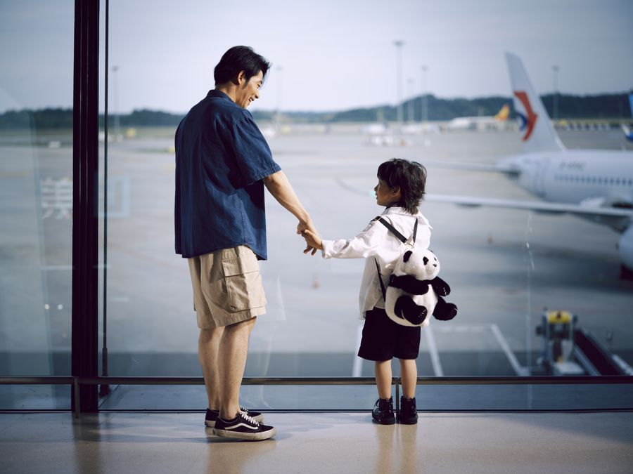 father and child holding hands at airport window — eSIM Troubleshooter works for anonymous visitors — answers first, signup never forced.