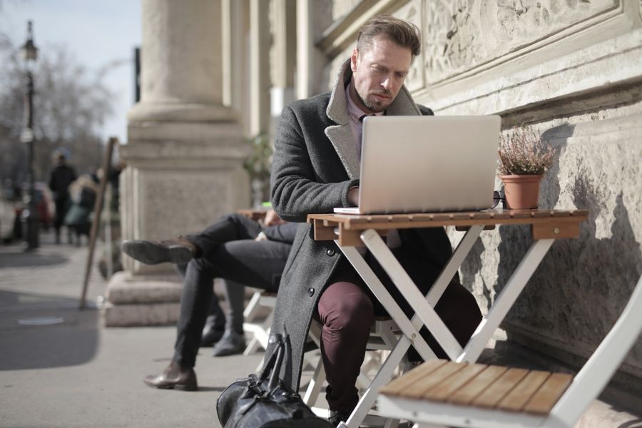 man in black jacket sitting on brown wooden folding chair using macbook — The capability matrix lists everything DNS Leak Test does — no asterisks.