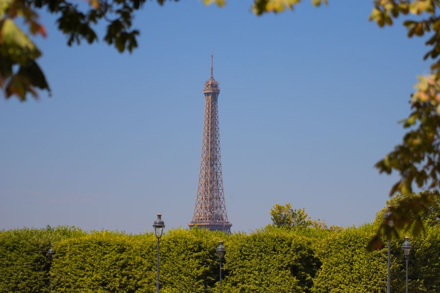 eiffel tower view through lush greenery in paris — Docs: Cada doc termina com “ainda travado?” — apontando para o Tele Agent.