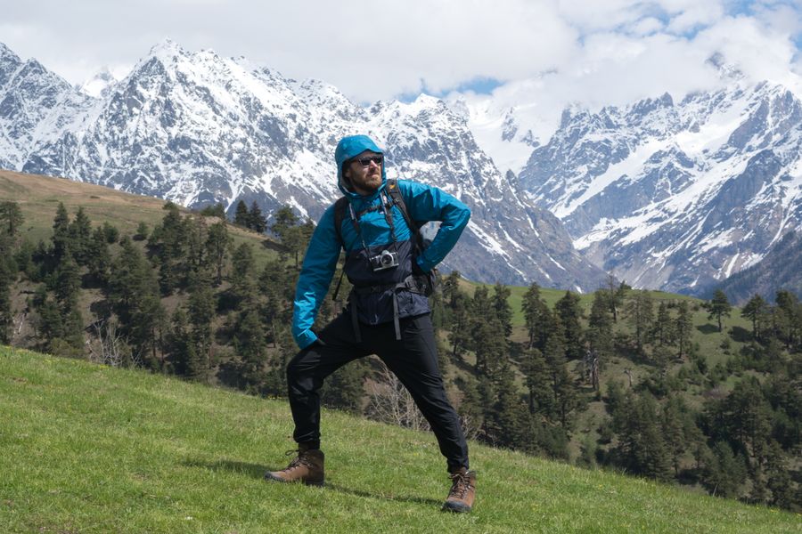 man standing on a grass with snow covered mountains background — Multi-Country eSIM Guide accepts your trip details and hands back a clear recommendation.