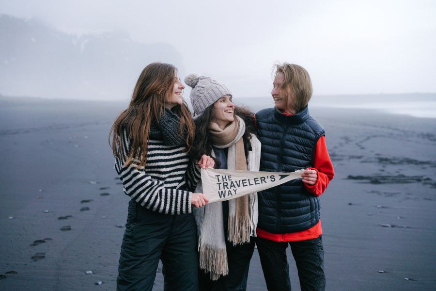 smiling women on beach in fog — Docs: Viajantes seguem online desde o pouso — sem filas de chip, sem susto de roaming.