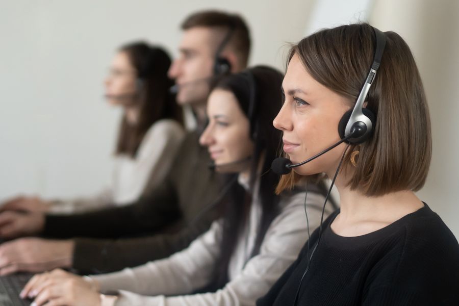 operators with headphones with microphone working on netbook in room