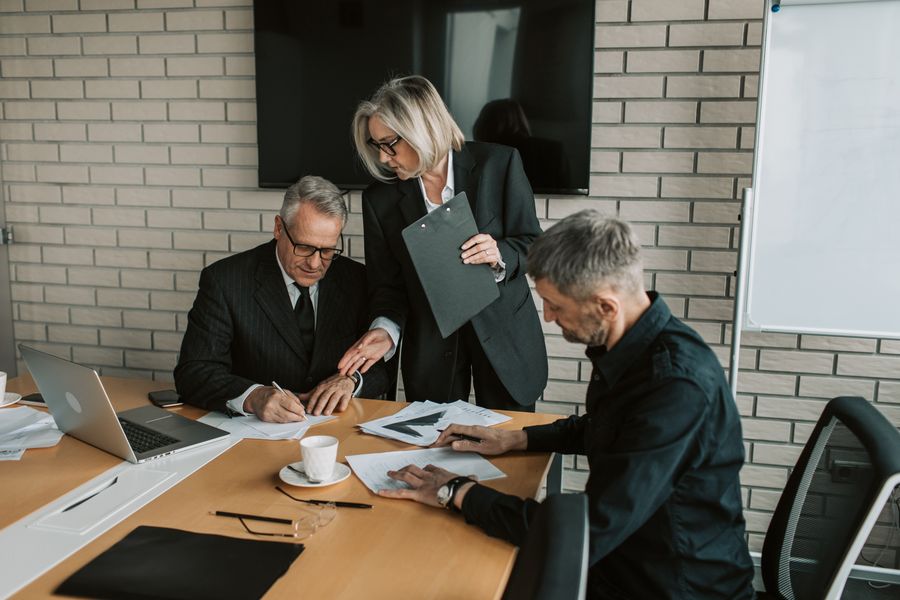 gray haired man signing the papers — Mercados de COUNTRY: pechinche com o conversor aberto, pague com um toque.