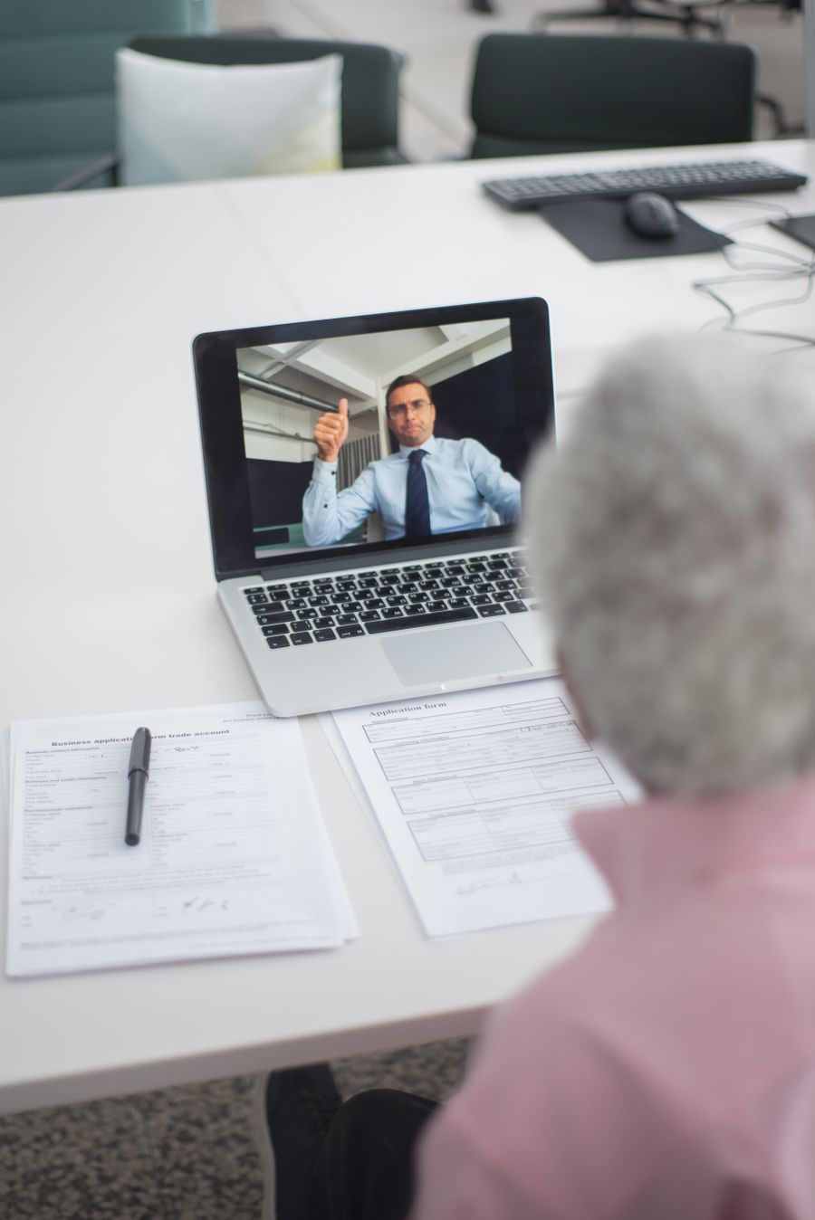 an elderly man on video call with an agent doing a hand sign — Nascer do sol sobre Mozambique: clima checado, botas calçadas, dados ligados.
