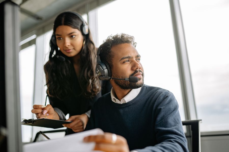 man and woman wearing headphones while working in the office — No account, no install, no waiting — Best Network by City loads and answers.