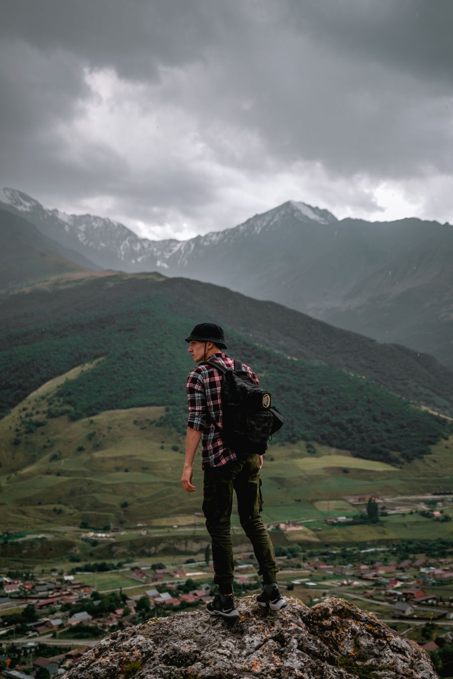 male hiker standing on the rock overlooking the green mountains — Support: Do saguão de embarque ao hall de chegadas, os dados nunca caem.