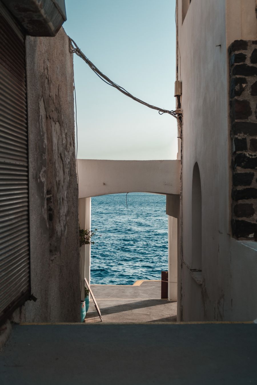 an empty alley near the ocean — Trilhas ao amanhecer começam com o clima — dados ligados, botas calçadas.