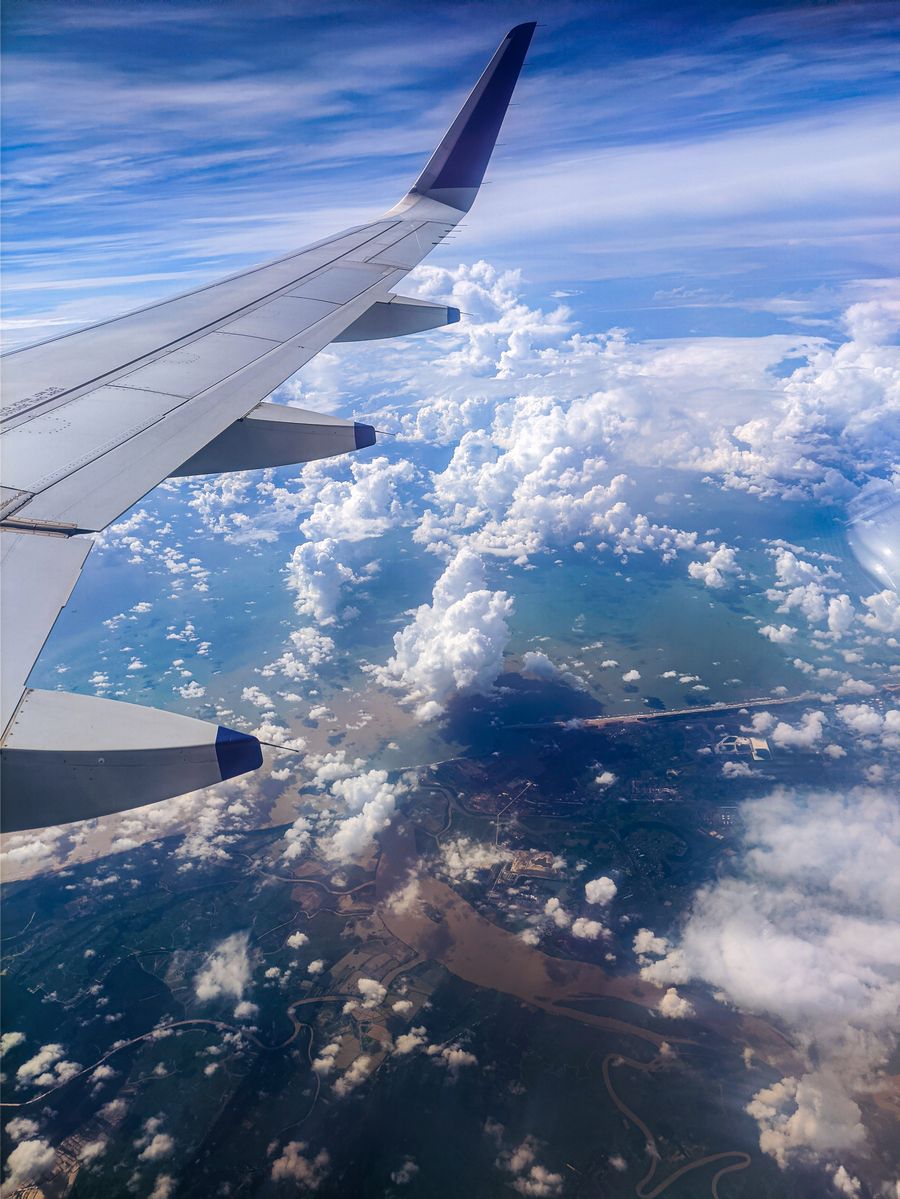photo of an airplane wing over white clouds — Dia de checkout em Brazil: late checkout pedido, táxi sincronizado com o voo.