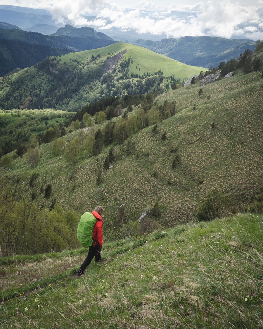 tourist hiking in grassy mountains — Docs: O escritório da janela: e-mails enviados em algum lugar sobre o oceano.